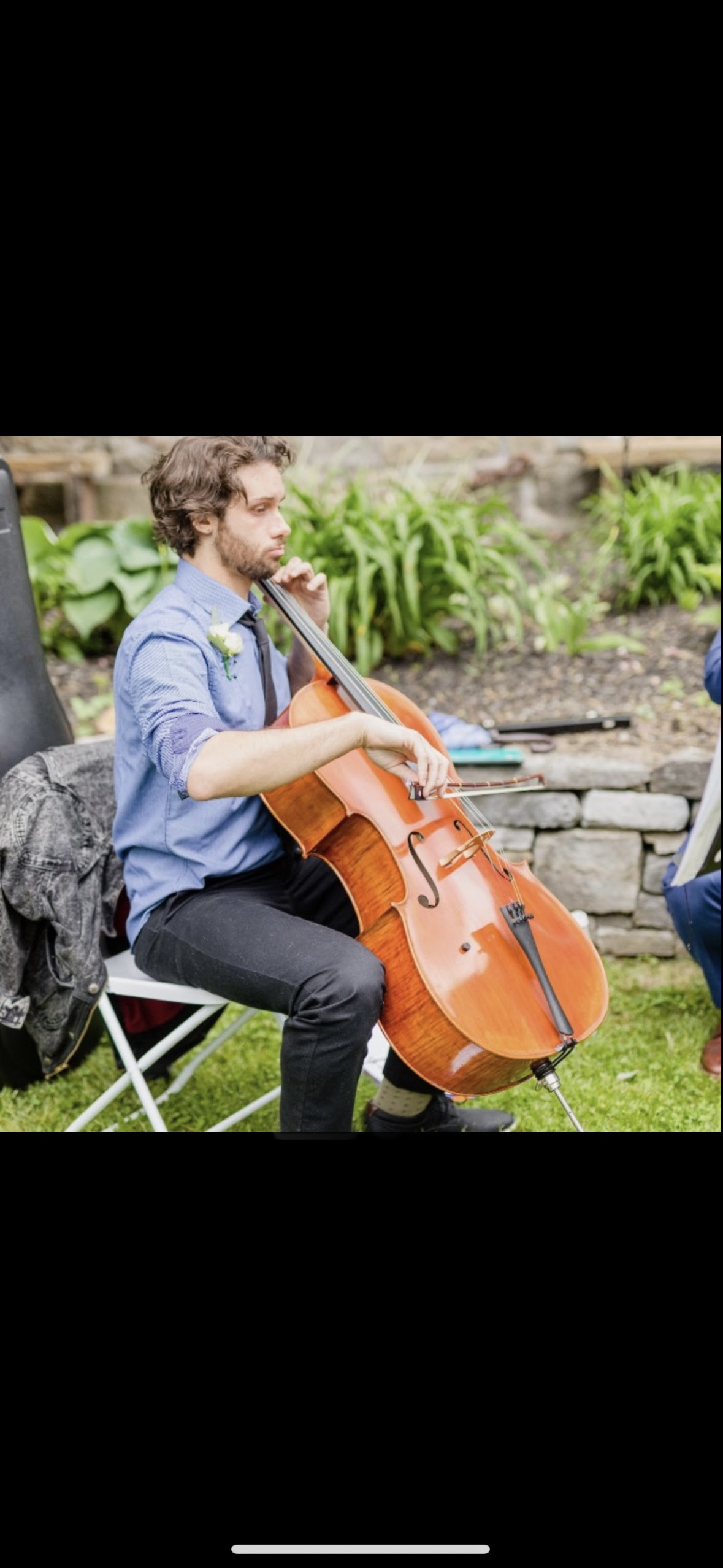 Kevin Wilson playing cello outdoors.